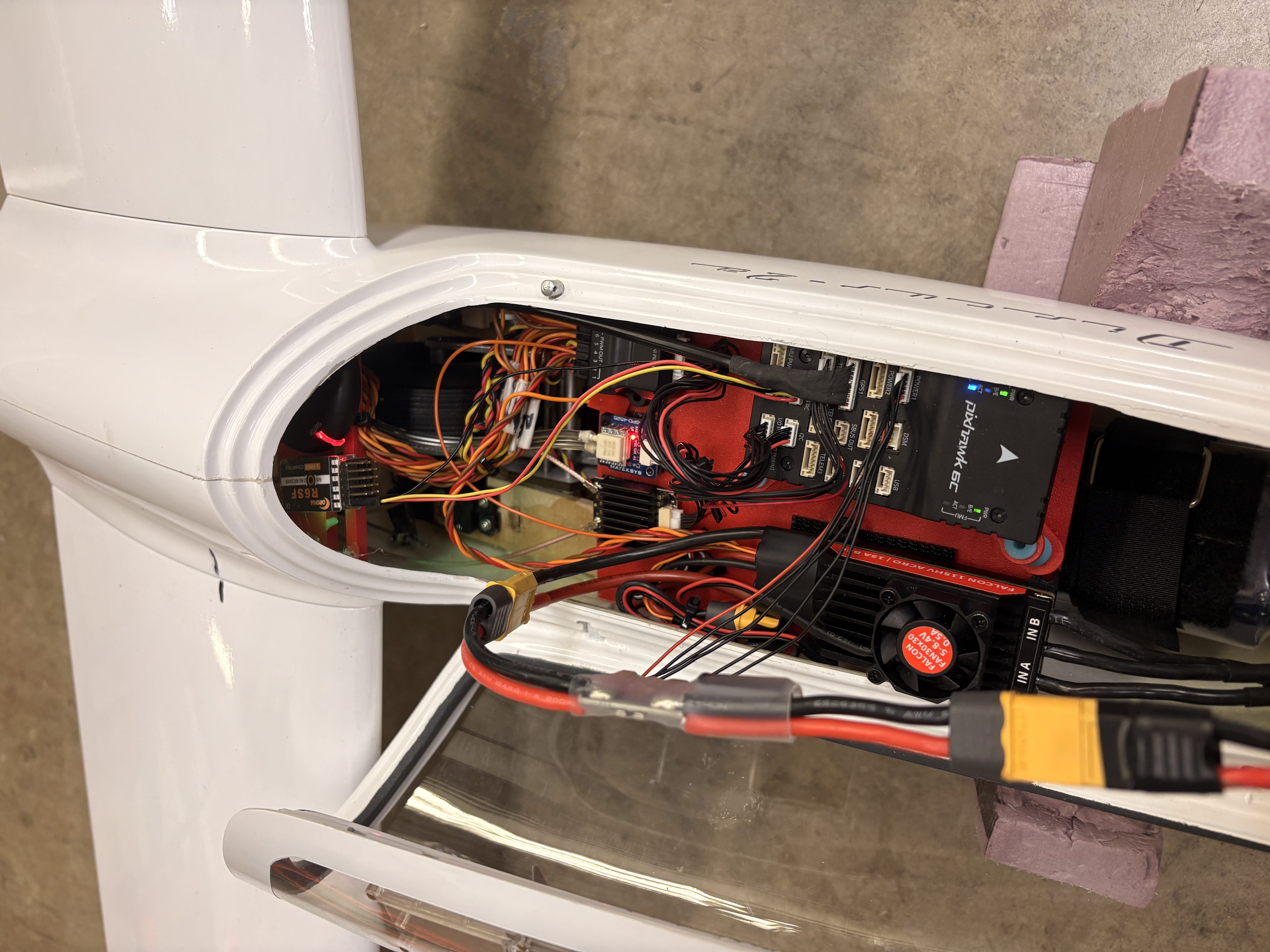 Pixhawk 6C flight controller and Falcon 115HV ESC wired into the fuselage avionics bay